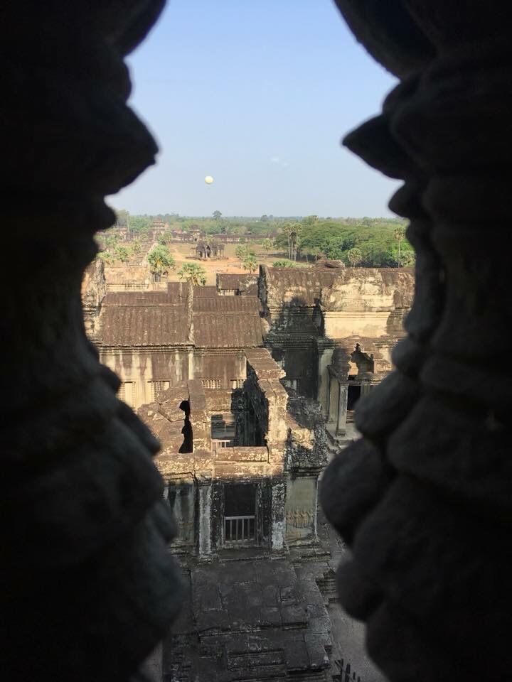 View through a carved temple window over the Angkor complex